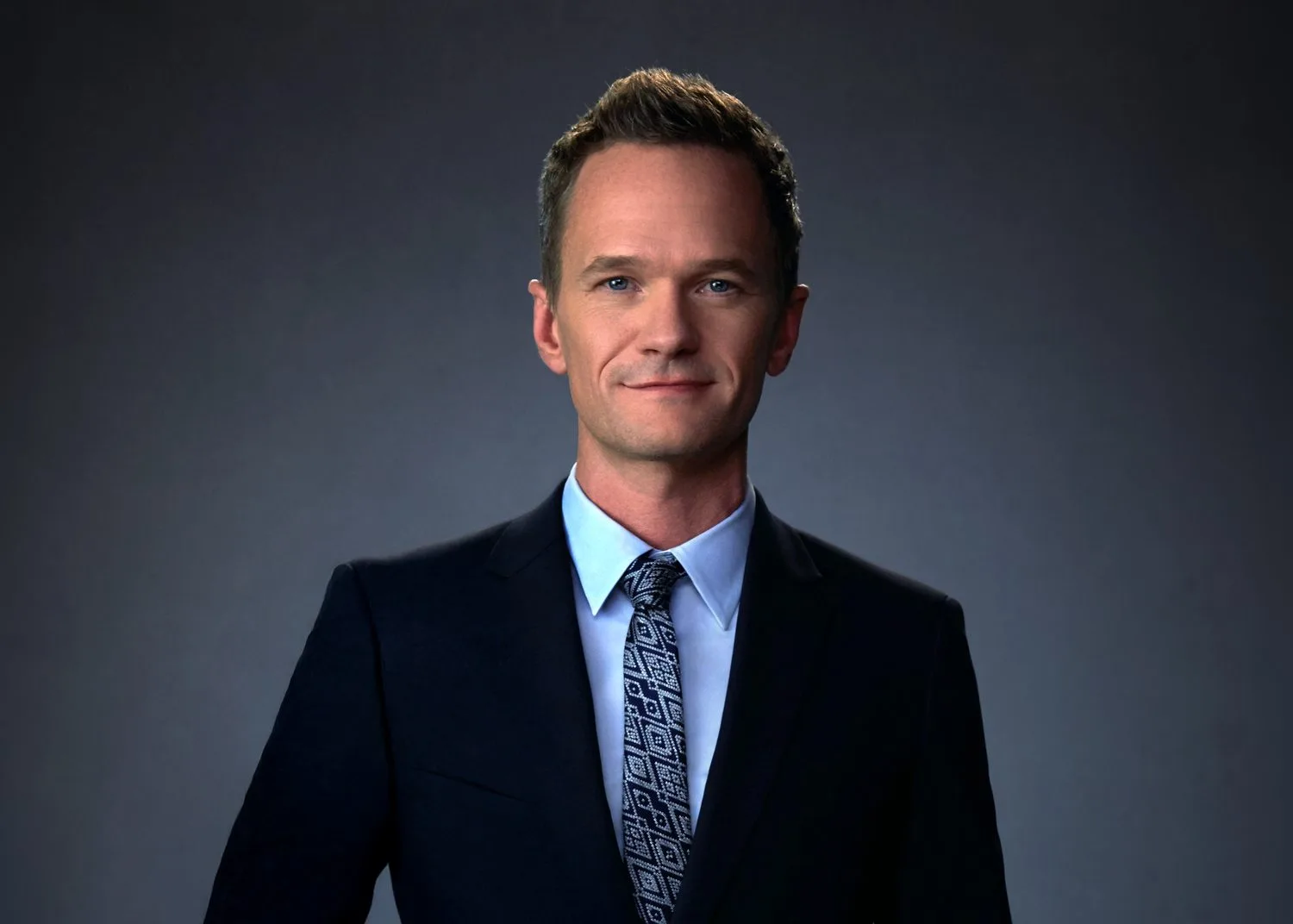 Neil Patrick Harris in a navy suit on a gray studio backdrop — celebrity headshot by Headshots LA in Los Angeles.